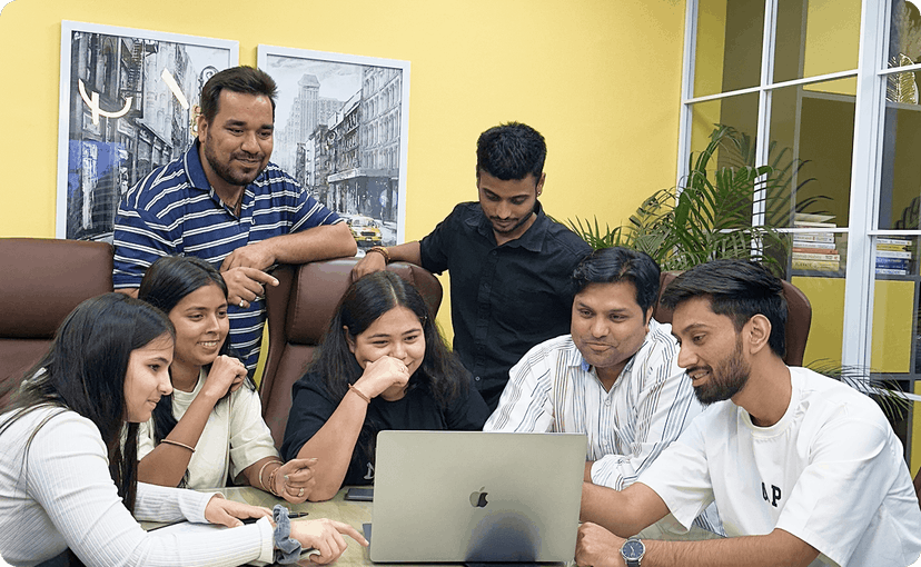 Diverse ZEP360 team collaborating around a laptop in the office